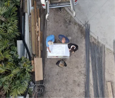 Aerial view of the Artegiano team reviewing construction plans on a job site